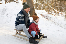 Father And Son Sledding During Winter