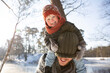 © Frank van Delft/Westend61 - Smiling son pulling knit hat over father's face during winter