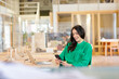 © Emma Innocenti/Westend61 - Smiling female entrepreneur using phone while sitting at desk in coworking office