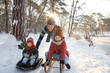 © Frank van Delft/Westend61 - Father sledding with sons on snow during winter