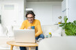 © Jose Carlos Ichiro/Westend61 - Smiling man holding mug while using laptop at home