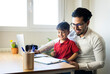© Jose Carlos Ichiro/Westend61 - Businessman and son smiling while looking at clipboard at home