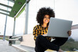 © Jose Carlos Ichiro/Westend61 - Smiling woman using laptop while sitting cross-legged on bench