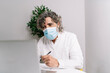 © COROIMAGE/Westend61 - Businessman wearing protective face mask while working on laptop at office during COVID-19