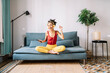 © COROIMAGE/Westend61 - Young woman looking away while listening music at home