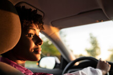 Young Woman Looking Away While Driving Car