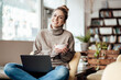 © Joseffson/Westend61 - Businesswoman with laptop smiling while holding bowl at coffee shop