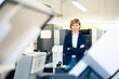 © Joseffson/Westend61 - Confident female entrepreneur standing by printing plant in factory