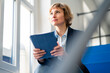 © Joseffson/Westend61 - Thoughtful female entrepreneur sitting with digital tablet in factory