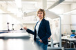 © Joseffson/Westend61 - Businesswoman with hand in pocket standing by digital tablet in factory