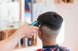 © Julio Rodriguez/Westend61 - Male hairdresser using machine to do hairstyle of teenage boy at barber shop