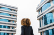 © Julio Rodriguez/Westend61 - Afro businesswoman standing in front of office building in city