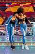 © Julio Rodriguez/Westend61 - African female friends leaning on railing at amusement park