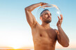 © Miguel Frias/Westend61 - Contemplating shirtless man wearing glass bowl during sunrise