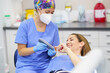 © Javier Sanchez Mingorance/Westend61 - Smiling female patient choosing tooth color of dental veneers held by dentist at clinic