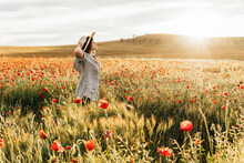 Mid Adult Woman Wearing Hat Standing In Poppy Field During Sunny Day