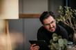© Malte Jager/Westend61 - Smiling male professional looking away while holding digital tablet at home