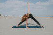 © OneInchPunch/Westend61 - Female athlete practicing yoga on exercise mat at beach