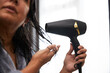 © Pete Muller/Westend61 - Woman drying hair using hair dryer at home