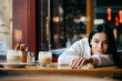 © alev/Westend61 - Woman resting while leaning on table at cafe