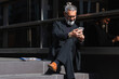 © NOVELLIMAGE/Westend61 - Male entrepreneur working on mobile phone while sitting on steps by building