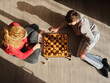 © Phillip Waterman/Westend61 - Mature woman playing chess with son at home