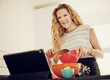© Phillip Waterman/Westend61 - Blond woman preparing food while watching tutorial on digital tablet