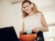 © Phillip Waterman/Westend61 - Woman watching tutorial on digital tablet while preparing food in kitchen