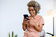 © Rafael Fernandez Torres/Westend61 - Smiling female entrepreneur using smart phone at home office