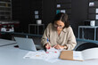 © NOVELLIMAGE/Westend61 - Female professional wearing eyeglasses writing on diary at office