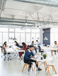© SERGIO NIEVAS/Westend61 - Male and female professionals working on laptop at coworking office