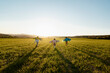 © Rafa Cortes/Westend61 - Brothers and sister with rocket wings running on agricultural field during sunny day