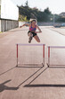 © CSSHOT/Westend61 - Young female athlete jumping over hurdle during sunny day