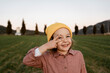 © Rafa Cortes/Westend61 - Smiling girl wearing knit hat gesturing peace sign while looking away