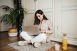 © Eva Blanco/Westend61 - Female professional sitting cross-legged while using laptop at home