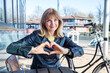 © Irina He√ü/Westend61 - Mature woman showing heart shape sign while sitting by bicycle