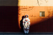 © Eugenio Marongiu/Westend61 - Woman astronaut in space suit standing by wall during sunset