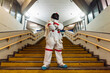 © Eugenio Marongiu/Westend61 - Male astronaut standing with arms crossed on staircase