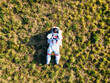 © Eugenio Marongiu/Westend61 - Young female astronaut lying on grass land