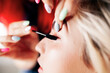 © Manu Reyes/Westend61 - Female make-up artist applying mascara on model's eyelashes at studio