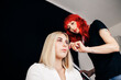 © Manu Reyes/Westend61 - Dyed haired hairstylist adjusting female model's hair at studio