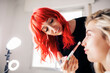 © Manu Reyes/Westend61 - Beautiful female make-up artist applying highlighter to model at studio