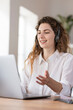 © steve brookland/Westend61 - Contented female customer service representative with headphones explaining to client headphones at desk in home office