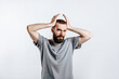 © Daria Lukoiko - Portrait of handsome young man frowning while holding hands near head on white background with space for advertising mock up