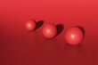 © Gemma Ferrando/Westend61 - Three dimensional render of three red striped spheres lying against red background