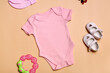 Close-up top view. Mockup blank pink newborn bodysuit for baby girl on beige background, with copy space - perfect baby clothes mockup template