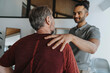 © Mareen Fischinger/Westend61 - Male physiotherapist with hand on shoulder of mature patient in medical practice