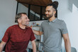 © Mareen Fischinger/Westend61 - Male physiotherapist with hand on shoulder of smiling patient in medical practice