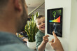 © Uwe Umstatter/Westend61 - Smiling boy with father using tablet while adjusting lights at smart home