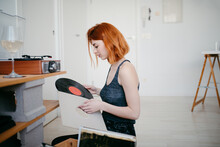 Woman Choosing Vinyl Record From Box At Home